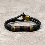Bracelet en cuir noir masculin avec ornements dorés et détails marron, style égyptien Horus.