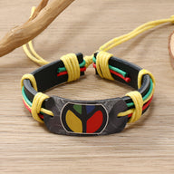 Bracelet homme en cuir noir avec plaque ovale multicolore style jamaïcain et cordons jaunes ajustables.