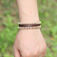 Bracelet homme en cuir marron tressé double tour avec surpiqûres blanches élégantes.