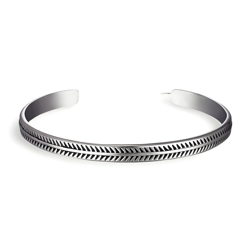 Bracelet ouvert en cuivre plaqué argent avec motif chevrons gravés, style épuré et masculin.