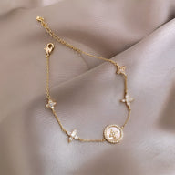 Bracelet fin en cuivre plaqué or avec pendentifs trèfle à 4 feuilles et chaîne délicate pour femme.