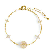 Bracelet en cuivre plaqué or avec trèfles à 4 feuilles et médaille centrale ornée de pierres blanches.