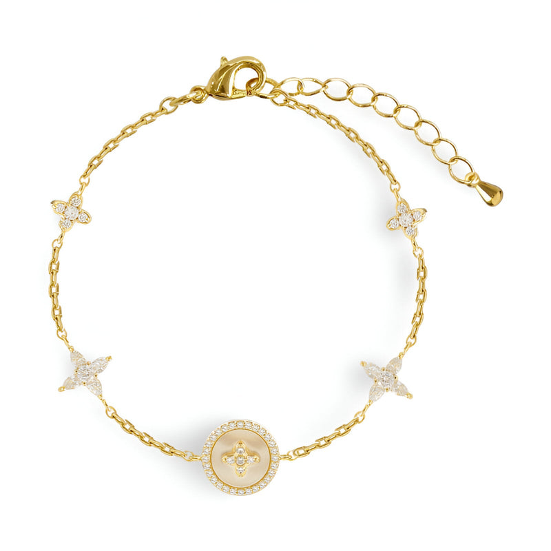 Bracelet en cuivre plaqué or avec trèfles à 4 feuilles et médaille centrale ornée de pierres blanches.