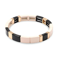 Bracelet rigide femme en émail noir, rose pâle et or, style segments rectangulaires lisses.