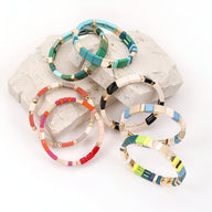 Bracelets en émail multicolores tons pastel et vifs, design rond moderne pour femme.