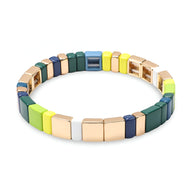 Bracelet en émail multicolore aux teintes vertes, bleues, jaunes et dorées, style moderne pour femme.