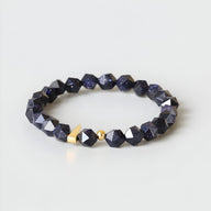 Bracelet mixte en grès bleu facetté avec perles dorées, style élégant et moderne.