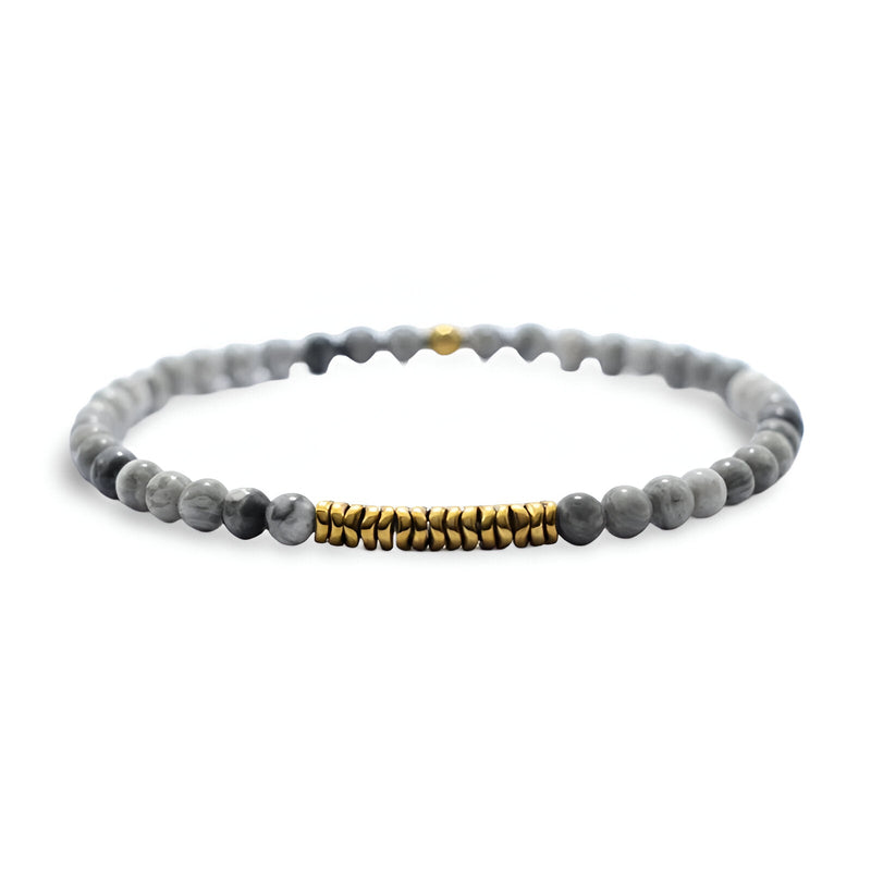 Bracelet fin pour homme en hématite et pierres naturelles gris clair avec perles dorées centrales.