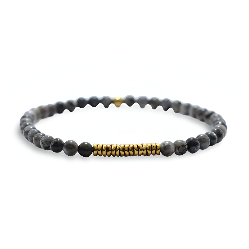 Bracelet fin en perles noires volcanique avec sections dorées, style masculin élégant.