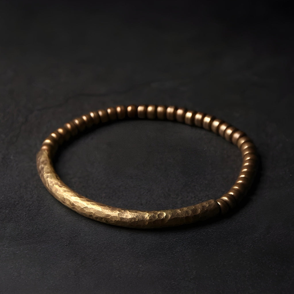 Bracelet femme en laiton avec petites perles marron et barre centrale texturée.