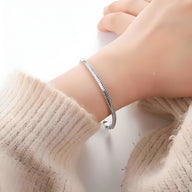 Bracelet jonc argenté en acier inoxydable à maille serpent, modèle Dolia porté au poignet.