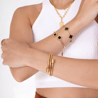 Bracelet jonc en titane doré flexible à maille serpent porté au poignet, design chic et moderne.