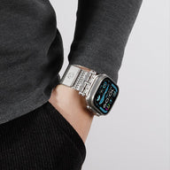 Bracelet en maille métallique argenté, ajustable et magnétique, porté avec Apple Watch à écran digital.