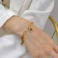 Bracelet en maille épaisse dorée avec pendentif arbre de vie en acier inoxydable sur poignet féminin.