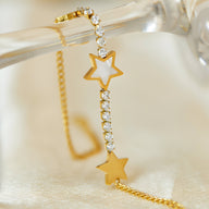 Bracelet en maille dorée avec étoiles évidée et pleine ornées de cristaux scintillants.