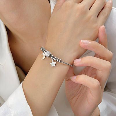 Bracelet en maille serpent argent avec pendentifs lune et étoile en acier inoxydable, style délicat.