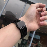 Bracelet en maille noire épaisse ajustable pour Apple Watch, modèle Forux, porté au poignet.