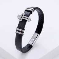 Bracelet homme en microfibre noire avec croix chrétienne argentée ornée de strass et fermoir métallique argenté.