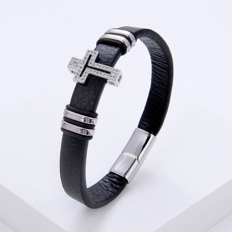 Bracelet homme en microfibre noire avec croix chrétienne argentée ornée de strass et fermoir métallique argenté.