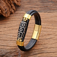 Bracelet homme en microfibre noir avec motif tibétain blanc, détails dorés et fermeture aimantée.