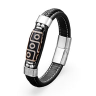 Bracelet homme en microfibre noire avec motif tibétain gravé sur pièce centrale et fermoir argenté brillant.