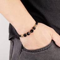 Bracelet homme microfibre noir avec pierres onyx facettées et perles dorées, style moderne.