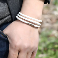 Bracelet en microfibre blanc tressé à enrouler trois tours avec fermoir métallique argenté.