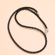 Bracelet en microfibre noir tressé simple à enrouler avec fermoir métallique argenté.