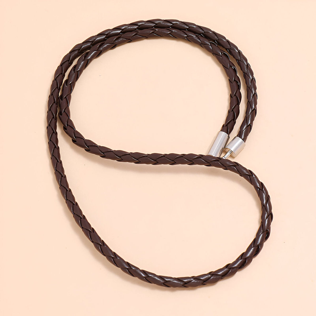 Bracelet en microfibre marron tressé, design simple à enrouler avec embouts métalliques argentés.