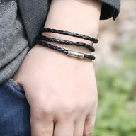 Bracelet en microfibre noir tressé à trois tours avec fermeture magnétique en métal argenté.