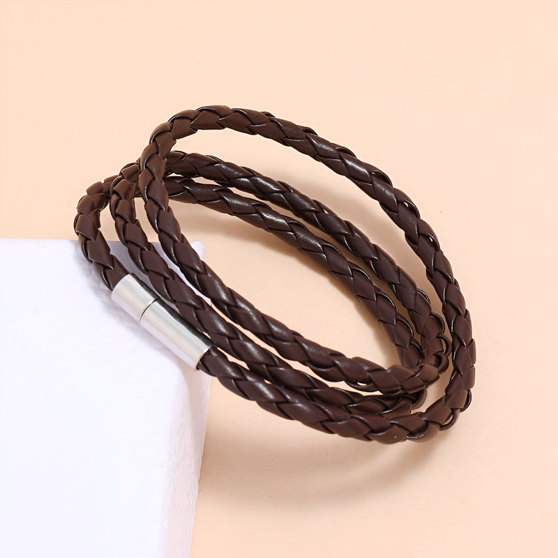 Bracelet en microfibre tressée marron à enrouler avec fermoir métallique argenté.