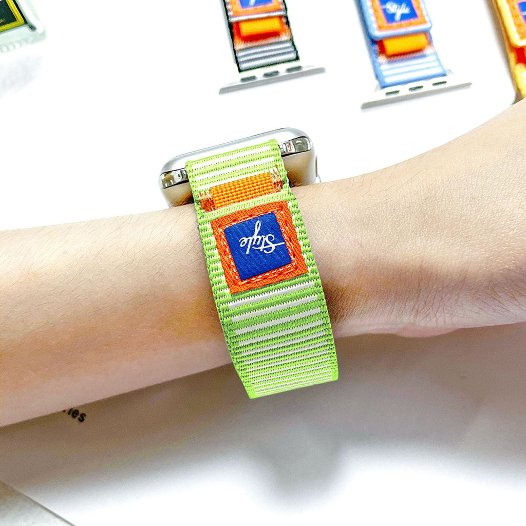 Bracelet Apple Watch nylon vert clair rayé avec patch bleu et boucle orange, ajustable.