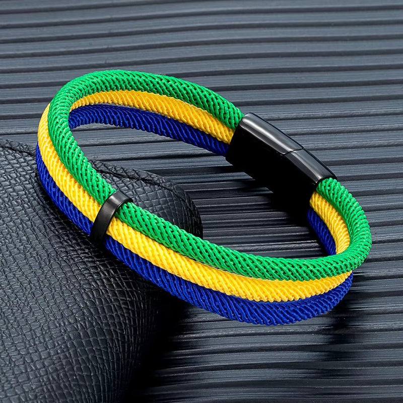 Bracelet en nylon tressé vert, jaune et bleu avec fermoir noir en métal.
