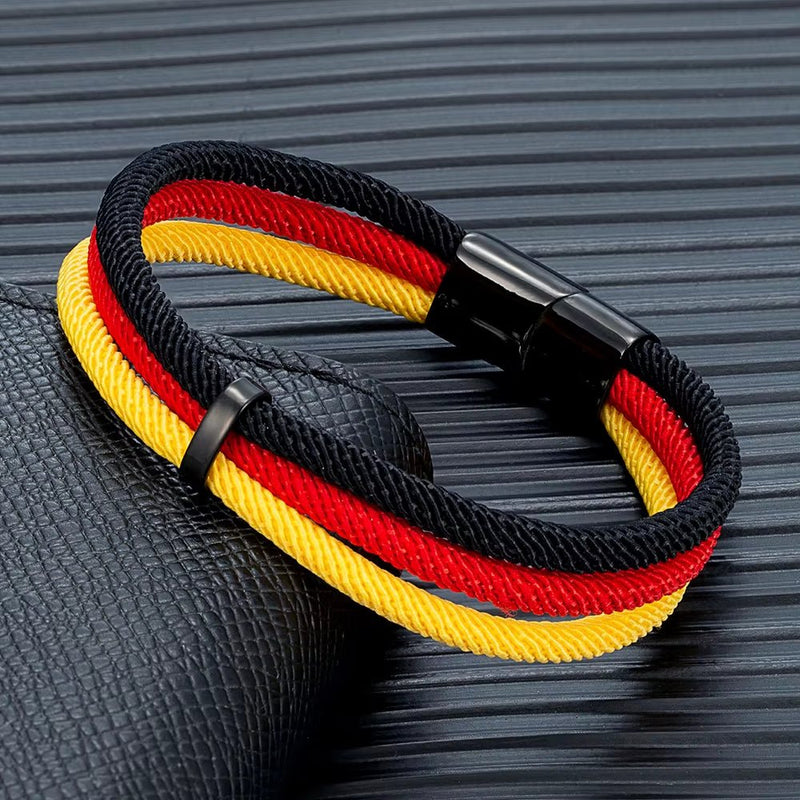 Bracelet en nylon tressé aux couleurs noir, rouge, jaune, fermoir magnétique noir brillant.