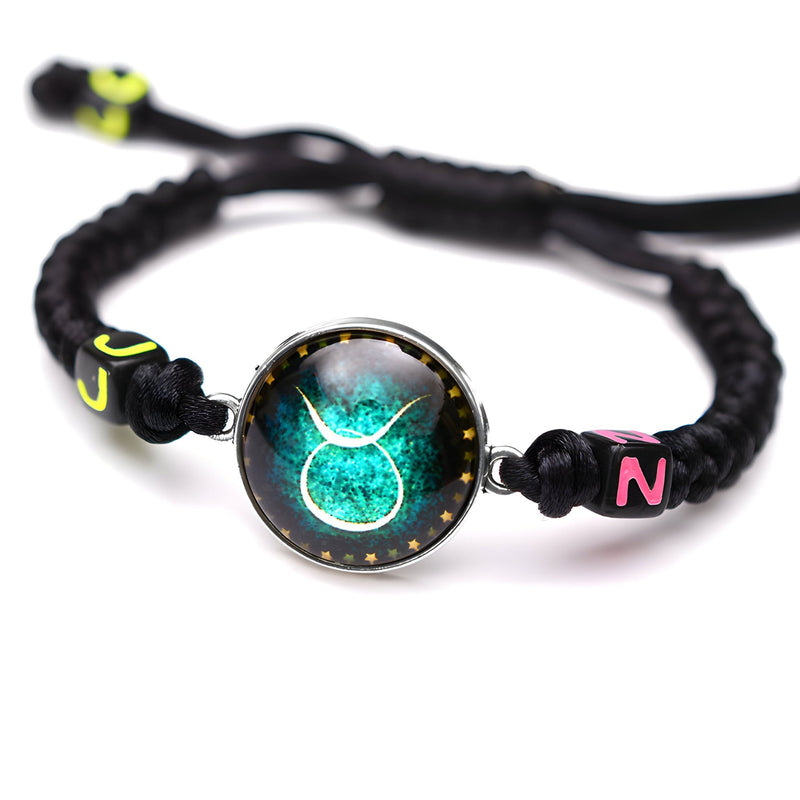 Bracelet en nylon noir ajustable avec signe zodiaque Taureau vert lumineux au centre et perles noires à détails jaunes et.
