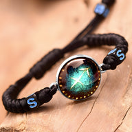 Bracelet en nylon noir avec cabochon vert et symbole du zodiaque Sagittaire bleu.
