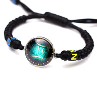 Bracelet en nylon noir tressé avec médaillon signe Gémeaux vert lumineux et détails jaunes et bleus.