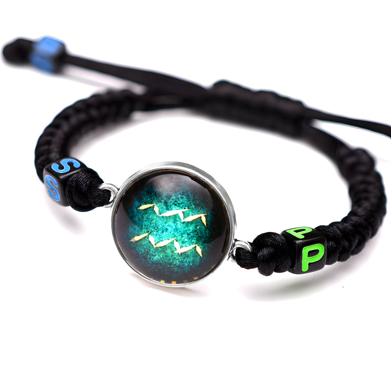 Bracelet en nylon noir avec signe du zodiaque Verseau vert et bleu sur médaillon rond transparent.