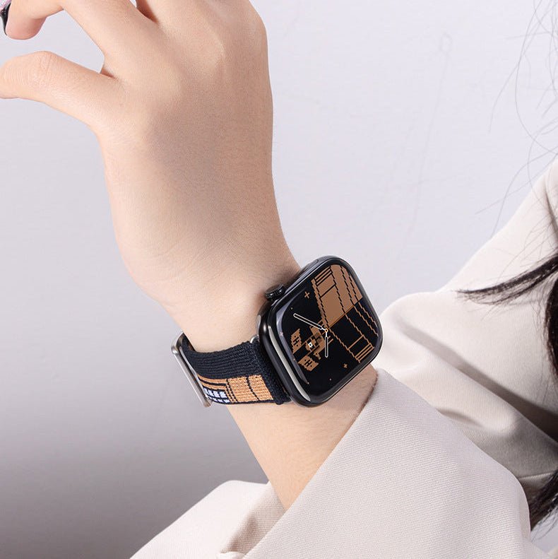 Bracelet Apple Watch en nylon tissé noir avec motifs géométriques beiges, boucle classique noire, style urbain moderne.