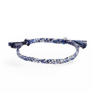 Bracelet en nylon tressé bleu et blanc avec fermoir coulissant et extrémités nouées.