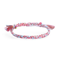 Bracelet en nylon tressé rose, bleu et blanc avec nœud coulissant et finition frangée.