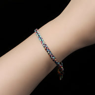 Bracelet en nylon tressé multicolore avec nuances de rose, bleu et blanc, style fin et ajustable sur poignet féminin.