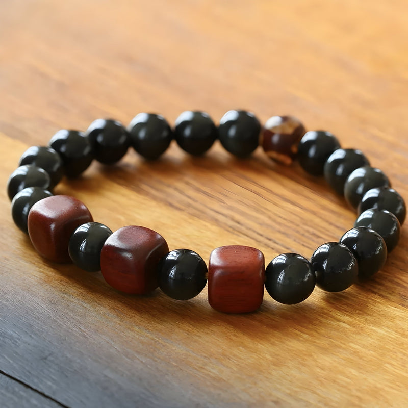 Bracelet mixte en perles rondes noires et cubes rouges en obsidienne arc-en-ciel sur corde élastique.