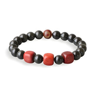 Bracelet mixte en perles d'obsidienne noire avec trois perles rouges en bois au centre.