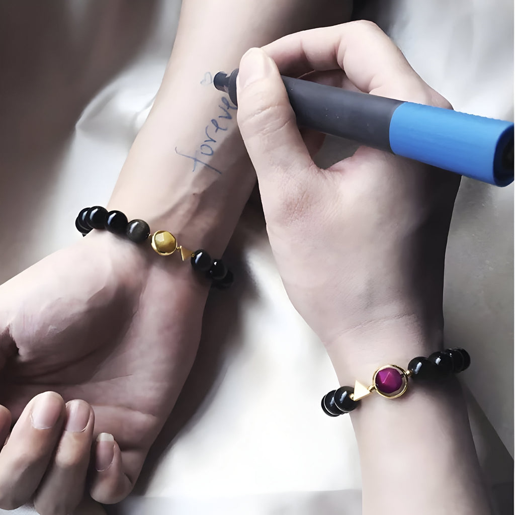 Bracelet mixte en obsidienne noire avec pierre oeil de tigre jaune et rose, modèle Eros, porté sur le poignet.