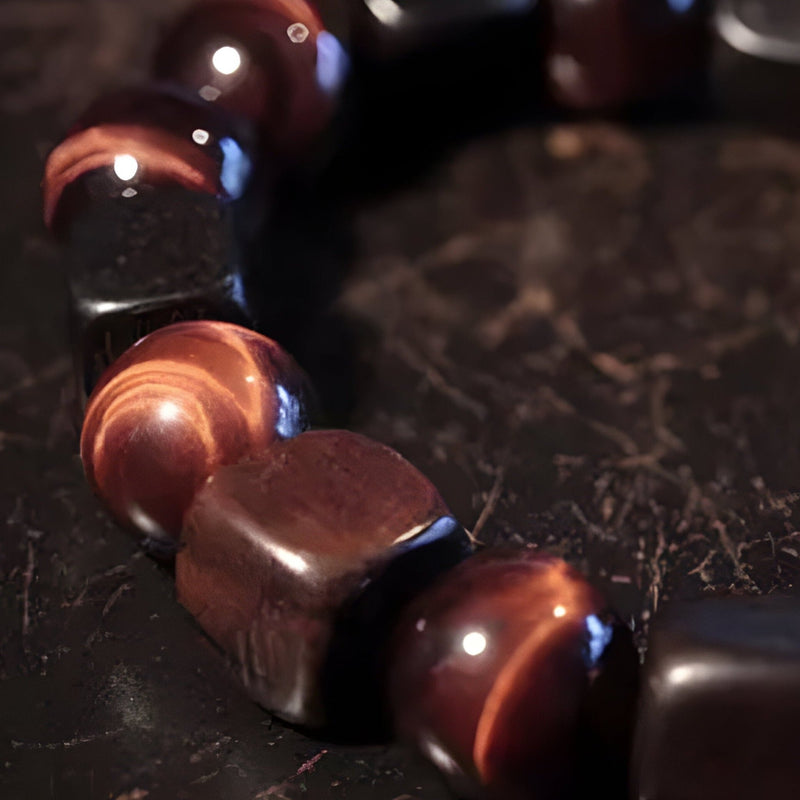 Bracelet mixte en perles rondes en œil de tigre rouge et cubes en bois d’ébène poli.