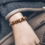 Bracelet femme en perles d'œil de tigre marron et cuivre, style élégant et léger.