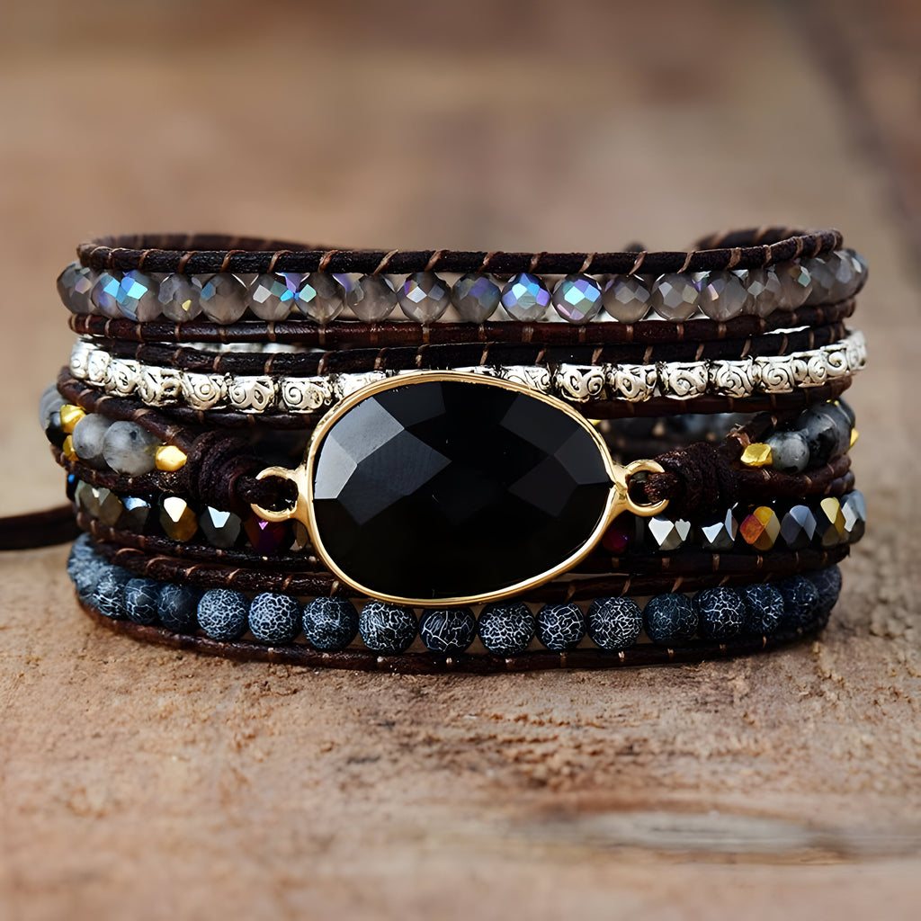 Bracelet multi-rangs noir avec pierre d'onyx facettée, perles d'agate, et rangées de strass éclatants.