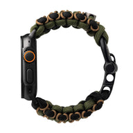 Bracelet en paracorde kaki et noir, tressé, avec fermeture ajustable pour Apple Watch noir, côté bouton orange visible.