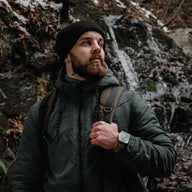 Bracelet paracorde noir ajustable SURVIVOR et EXPLORATEUR pour Apple Watch porté en extérieur sur poignet homme.